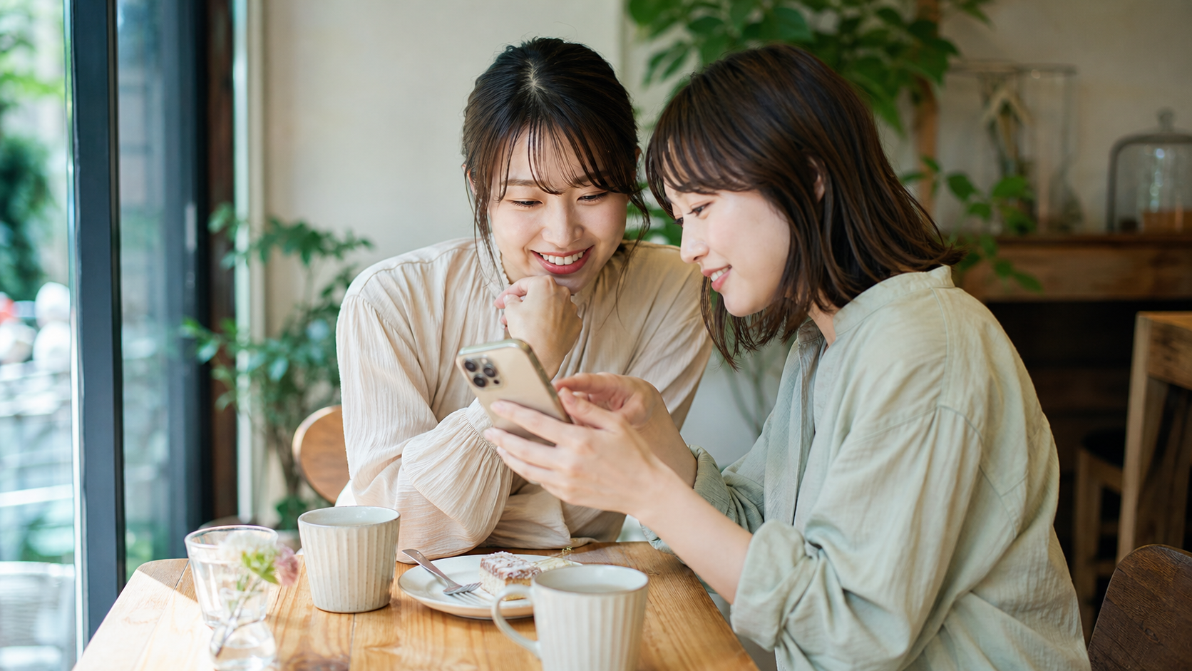 スマホで写真を確認して自然な一枚を選ぶ友人同士