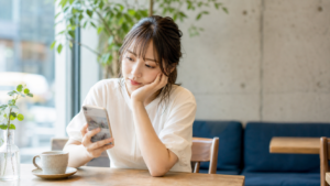 スマホを見てリア充アピールに疲れを感じる女性