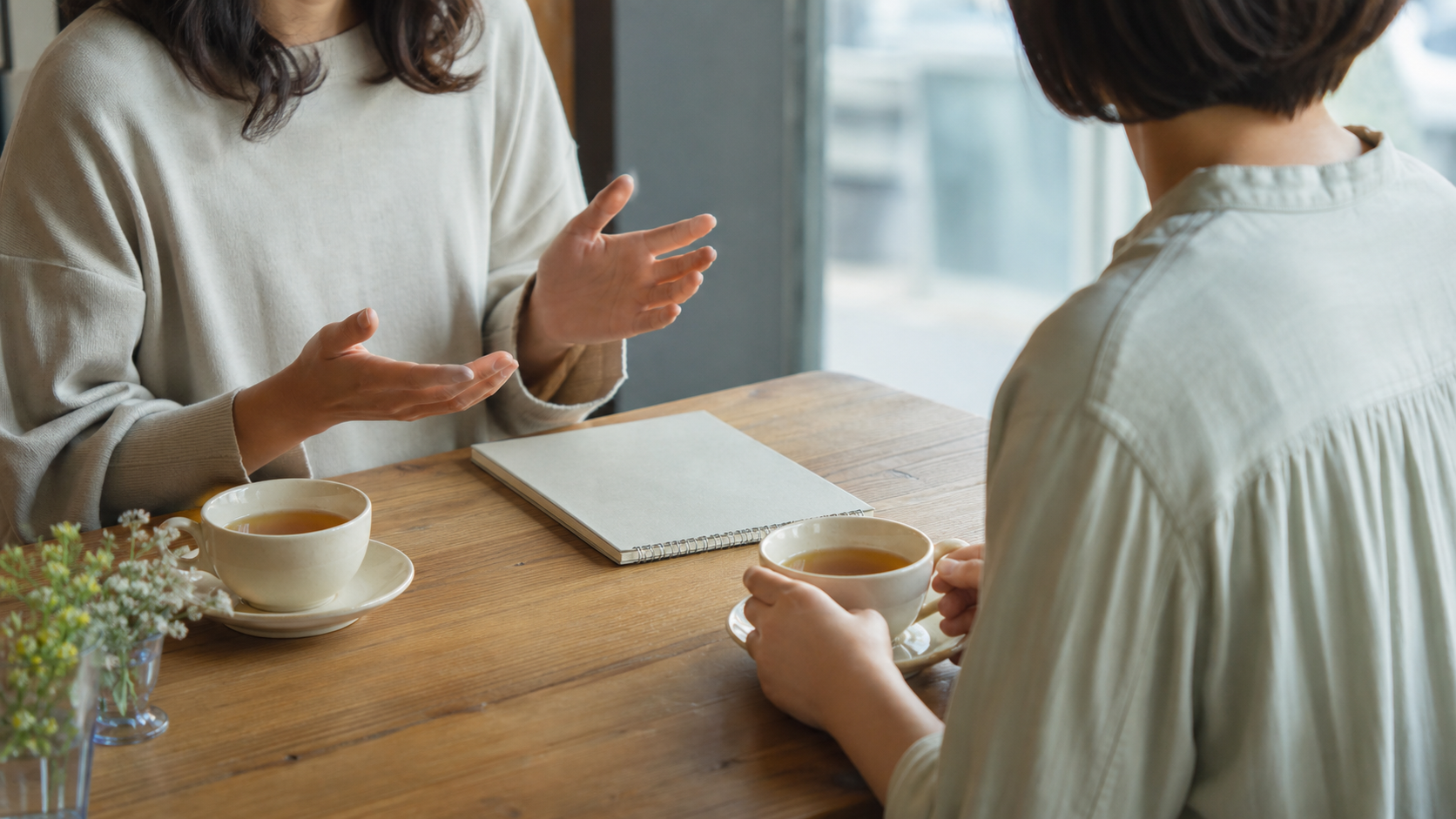 信頼できる友人に嫉妬やつらさを相談するカフェの場面