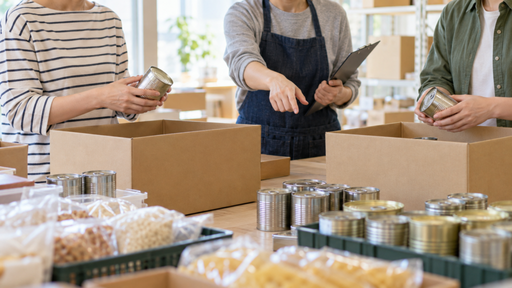 食品の仕分けを担当者の説明を受けながら行う成人
