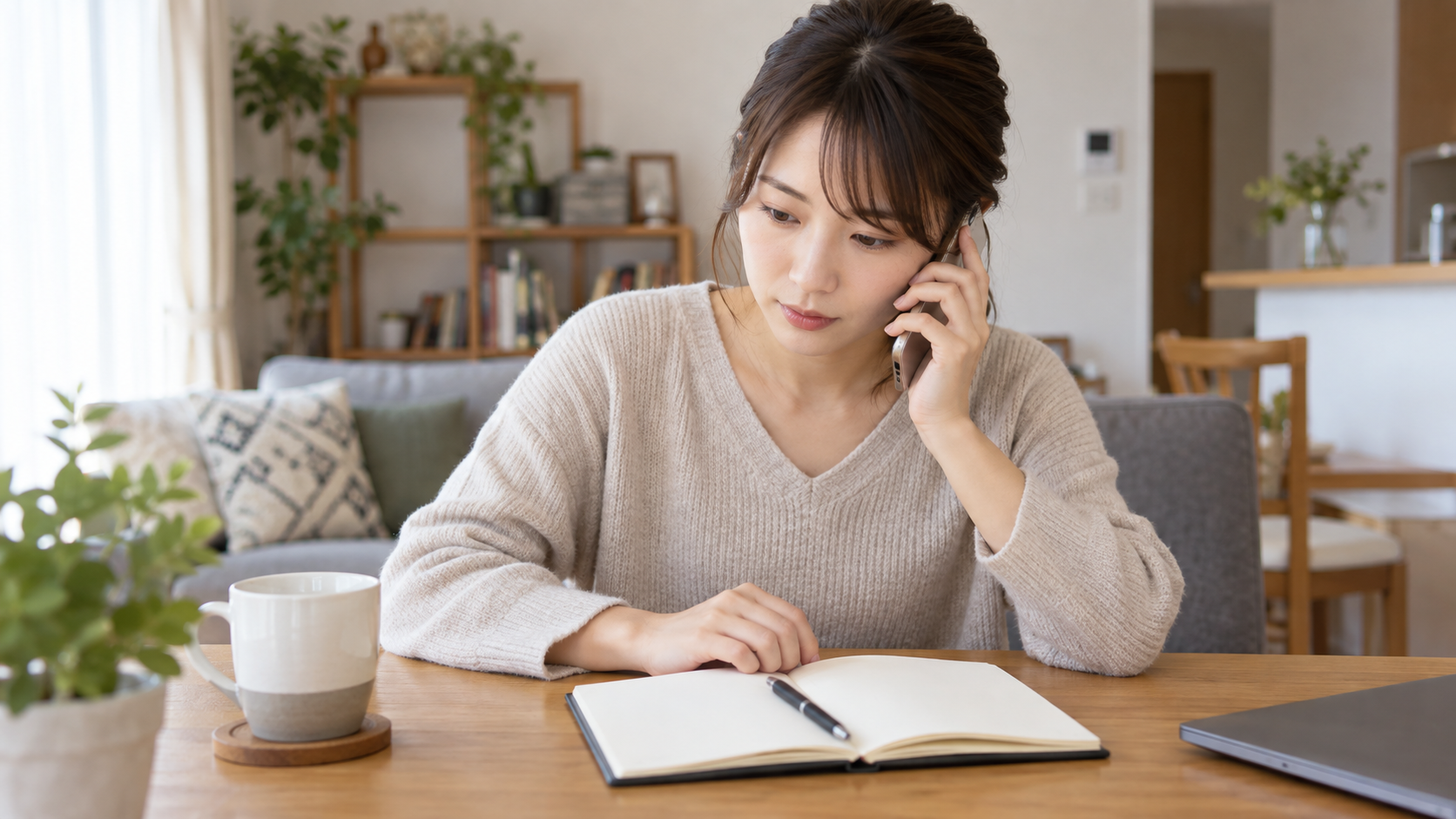 開いたノートを見ながら電話で確認する女性
