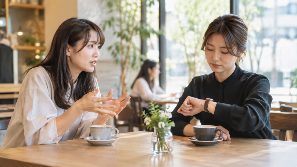 友達の話を聞きながら時間を確認する人