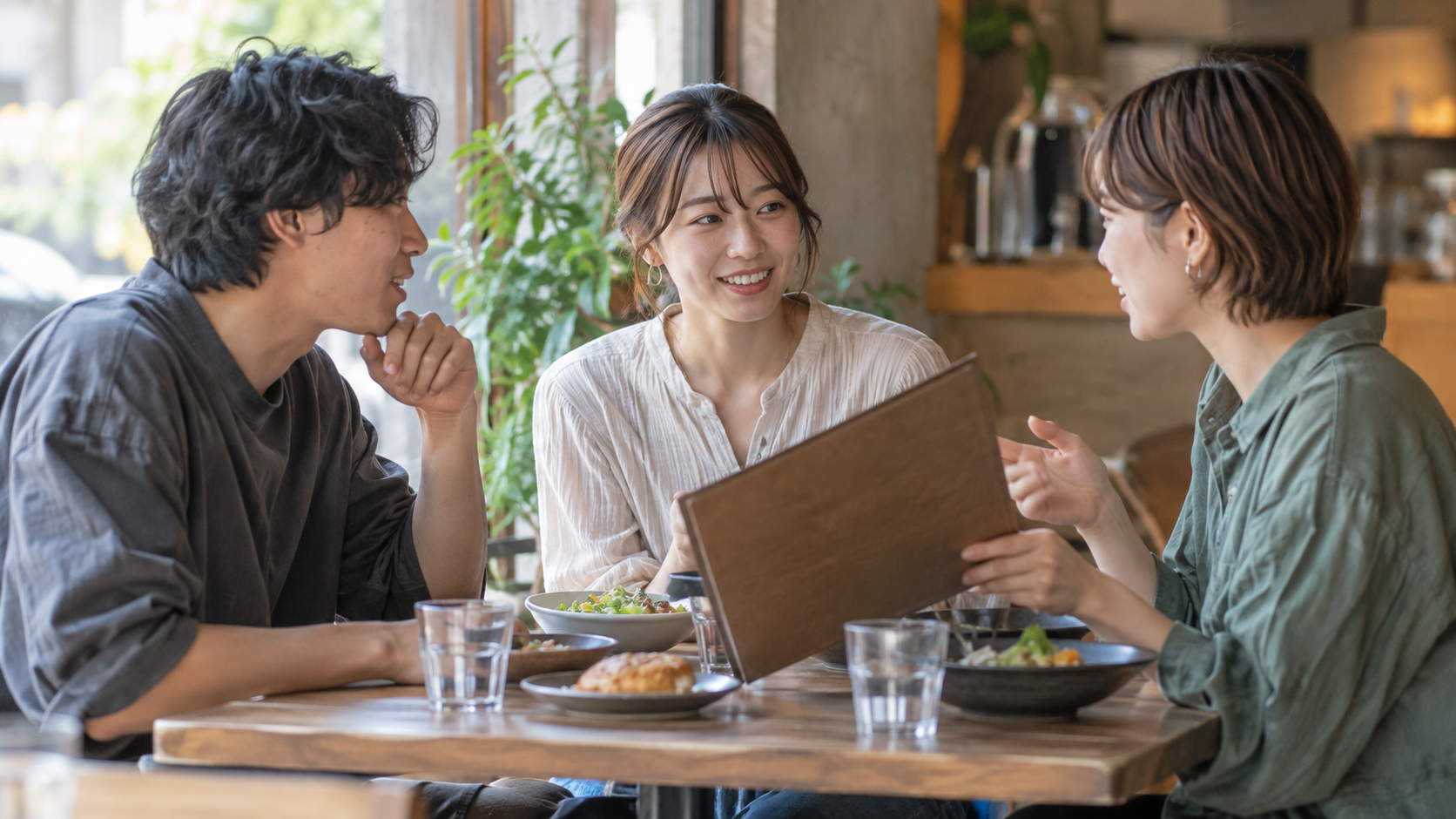 カフェで食事の予定を相談する三人の友達