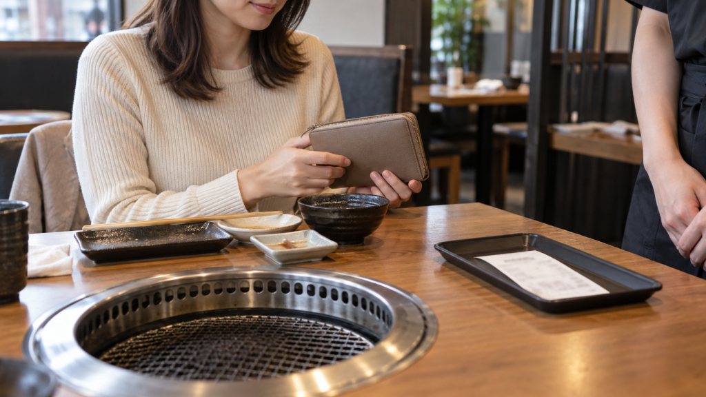 食後に財布と伝票を手元で確かめる様子