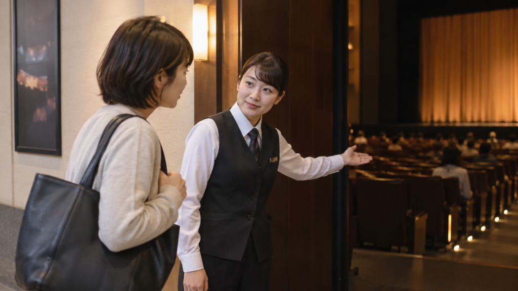 客席入口で係員に案内を尋ねる一人の観客